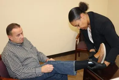 Person getting an ankle monitoring device checked.